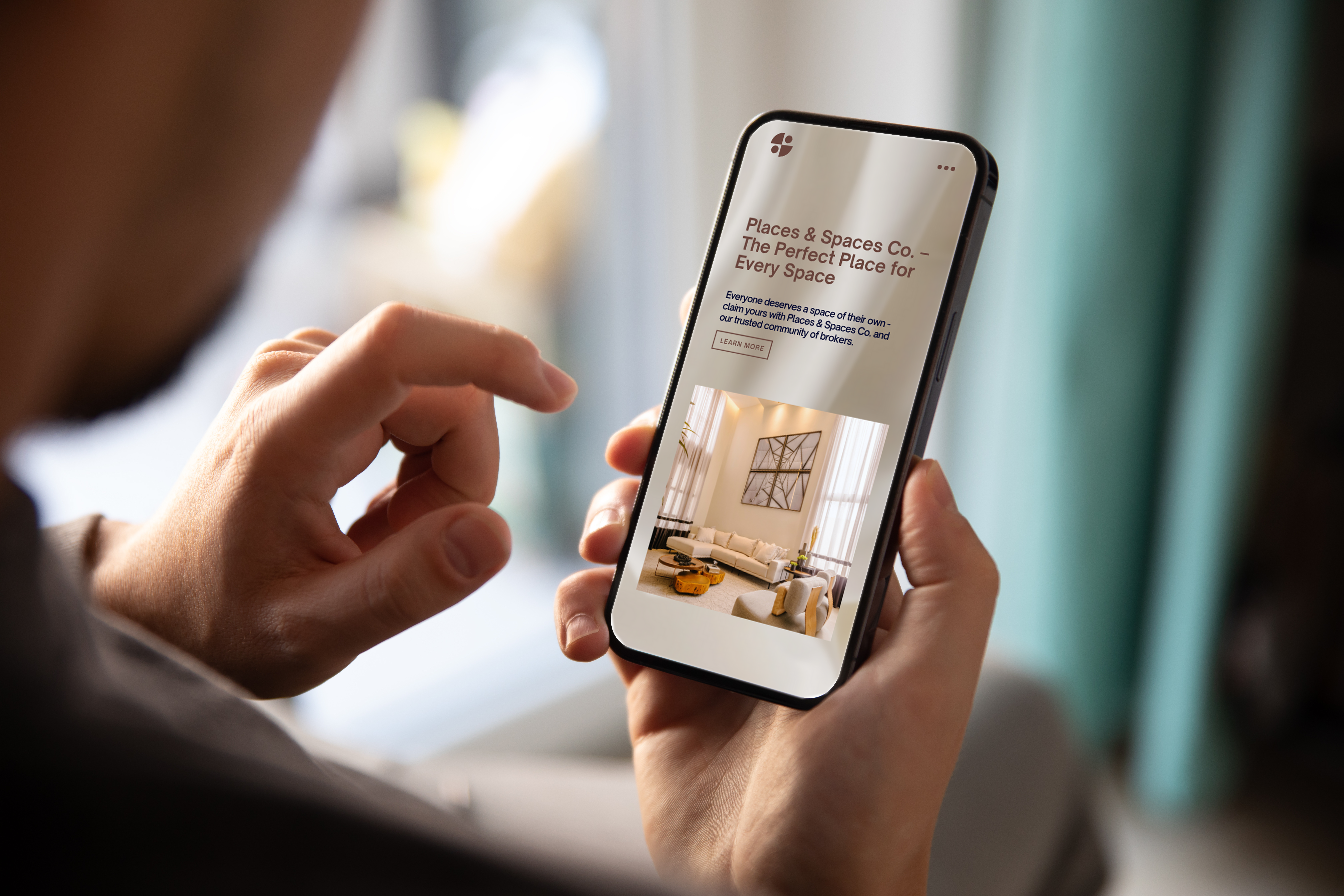 man holding a phone looking at a website mockup